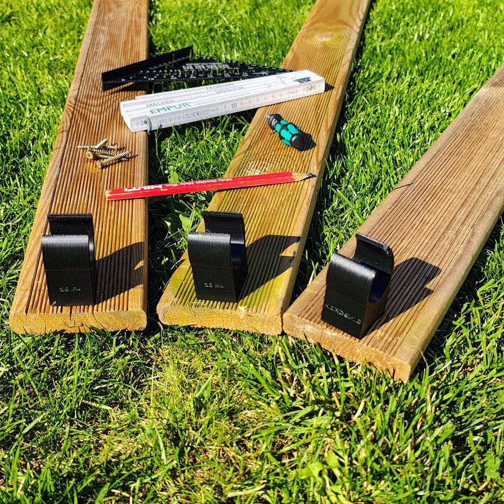Clipper Jump Unterfahrschutz an drei Terrassendielen – Nahaufnahme der montierten Clips